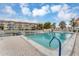 Community pool with clear blue water, white fence surround, and condo buildings in the background at 1250 N Portofino Dr # 304, Sarasota, FL 34242
