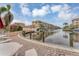 Serene waterfront view of a canal with boats docked, condo buildings, and lush tropical landscaping at 1250 N Portofino Dr # 304, Sarasota, FL 34242
