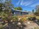 The back of the house featuring a wooden deck and a beautifully landscaped garden area at 1350 40Th St, Sarasota, FL 34234