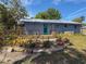 Back of the home showcasing a wooden deck, mature trees, and thoughtfully designed landscaping at 1350 40Th St, Sarasota, FL 34234