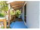 Relaxing covered porch with wood floors, partial shade, and ample seating, perfect for enjoying the outdoors at 1350 40Th St, Sarasota, FL 34234