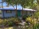 Charming home exterior with a well-manicured garden, a bright green door, and a welcoming pathway at 1350 40Th St, Sarasota, FL 34234