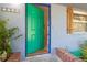 Charming blue home, showing an open green front door with brick trim and lush landscaping at 1350 40Th St, Sarasota, FL 34234