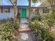 Charming home's front exterior with a decorative walkway, lush plants and blue-green door at 1350 40Th St, Sarasota, FL 34234