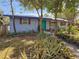 Charming home exterior with lush landscaping, green door and beautiful window shutters at 1350 40Th St, Sarasota, FL 34234
