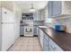 Charming kitchen features custom blue and white cabinets, updated appliances, and a decorative backsplash at 1350 40Th St, Sarasota, FL 34234