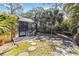 This backyard features an enclosed pool area and lush trees at 1621 Overbrook Rd, Englewood, FL 34223