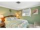 Guest bedroom with tropical bedding, accent wall, and a charming bedside table at 1621 Overbrook Rd, Englewood, FL 34223