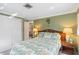 Tropical bedroom with bright bedding, wood headboard, and a peek into the hallway at 1621 Overbrook Rd, Englewood, FL 34223