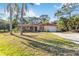 Charming single-story home with well-manicured lawn, mature palm trees, and attached one-car garage at 1621 Overbrook Rd, Englewood, FL 34223