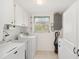 Bright laundry room with modern washer and dryer and ample cabinet space at 1621 Overbrook Rd, Englewood, FL 34223