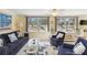 Inviting living room featuring large windows, comfortable seating, and nautical-themed decor at 1621 Overbrook Rd, Englewood, FL 34223