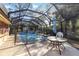 Enclosed pool area with a table and chair to enjoy the pool at 1621 Overbrook Rd, Englewood, FL 34223