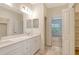Bathroom with dual sinks, large mirror, and access to a walk-in closet at 18249 Vizcaya Ct, Venice, FL 34293