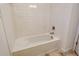 Modern bathroom featuring a subway-tiled bathtub with sleek, chrome fixtures at 18249 Vizcaya Ct, Venice, FL 34293