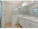 Bathroom features double vanity sinks and a walk in shower with tile surround at 18249 Vizcaya Ct, Venice, FL 34293