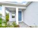 A covered front porch with a blue door, white columns, and gray pavers provides a welcoming entrance at 18249 Vizcaya Ct, Venice, FL 34293