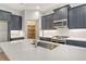 Close-up of a kitchen island with a stainless sink, gray cabinets, and stainless appliances at 18249 Vizcaya Ct, Venice, FL 34293
