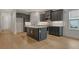 Open kitchen showcases stainless appliances, gray cabinets, sleek countertops, and light wood floors at 18249 Vizcaya Ct, Venice, FL 34293