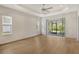 A spacious main bedroom features wood floors, a ceiling fan, and sliding glass doors to the lanai at 18249 Vizcaya Ct, Venice, FL 34293