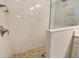 Walk-in shower with white subway tile surround and brown mosaic tile floor at 18249 Vizcaya Ct, Venice, FL 34293