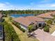 Aerial view of a home with a red tile roof and scenic lake view at 20655 Valprato Ct, Venice, FL 34293