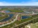 Wide aerial view of the community featuring waterfront properties, lush landscaping, and interconnected roads at 20655 Valprato Ct, Venice, FL 34293