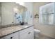 This bathroom features a window, white vanity, and shower at 20655 Valprato Ct, Venice, FL 34293
