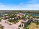 Aerial view of the community center, pool, and lush landscaping surrounding lakefront homes at 20655 Valprato Ct, Venice, FL 34293