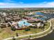Aerial shot highlights a large community pool, clubhouse, tennis courts, and verdant landscaping under a sunny sky at 20655 Valprato Ct, Venice, FL 34293