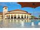 Resort-style community pool with ample seating and umbrellas near the clubhouse and landscaping at 20655 Valprato Ct, Venice, FL 34293