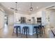 A well-lit kitchen featuring white cabinets, stainless steel appliances, and a granite island with bar stool seating at 20655 Valprato Ct, Venice, FL 34293