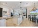Bright, open-concept kitchen with white cabinets, granite countertops, and stainless steel appliances at 20655 Valprato Ct, Venice, FL 34293