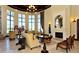 Community living room with fireplace, chandelier, large windows, and elegant decor at 20655 Valprato Ct, Venice, FL 34293