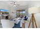 Inviting living room with blue accents, a ceiling fan, and sliding glass doors leading to a scenic view at 20655 Valprato Ct, Venice, FL 34293