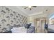 This main bedroom features a trey ceiling, patterned wallpaper, and en suite bath at 20655 Valprato Ct, Venice, FL 34293