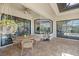 Covered patio with outdoor seating and dining table provides a relaxing space overlooking the landscaped backyard at 20655 Valprato Ct, Venice, FL 34293