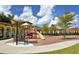 Community playground featuring a slide, swings, and shade structure in a landscaped area at 20655 Valprato Ct, Venice, FL 34293