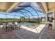 The covered lanai features a screened pool and spa for relaxing outdoors at 20655 Valprato Ct, Venice, FL 34293