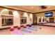 Community yoga studio with mats, exercise balls, mirrored wall, and TV at 20655 Valprato Ct, Venice, FL 34293