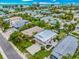 Aerial view of a charming home with lush greenery and a long driveway in a coastal community at 216 Palmetto Ave, Anna Maria, FL 34216