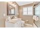 Bathroom vanity features a decorative mirror, a stone countertop, and soft, neutral-colored walls at 216 Palmetto Ave, Anna Maria, FL 34216