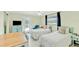 Bright bedroom featuring two beds, a ceiling fan, light green walls, and access to a balcony with natural light at 216 Palmetto Ave, Anna Maria, FL 34216