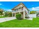 Charming two-story home featuring a covered balcony and well-manicured lawn at 216 Palmetto Ave, Anna Maria, FL 34216