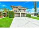 Charming two-story home featuring a covered balcony, two-car garage, and well-manicured lawn at 216 Palmetto Ave, Anna Maria, FL 34216