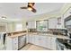 Bright kitchen with granite counters, stainless appliances, tiled backsplash, bar seating, and ample cabinet space at 216 Palmetto Ave, Anna Maria, FL 34216
