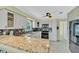 Well-lit kitchen featuring granite countertops, stainless steel appliances, mosaic backsplash, and ample cabinet space at 216 Palmetto Ave, Anna Maria, FL 34216