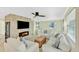 Cozy living room with stone fireplace, flat screen TV, light tile floor, and comfortable seating arrangements at 216 Palmetto Ave, Anna Maria, FL 34216