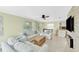 Bright living room with white furniture, ceiling fan, and tile flooring, open to a modern kitchen with counter seating at 216 Palmetto Ave, Anna Maria, FL 34216