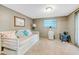 Cozy living area with a white daybed, neutral walls, and ample natural light from the window at 216 Palmetto Ave, Anna Maria, FL 34216